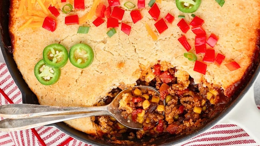 The Cowboy Cornbread Casserole is served in a cast iron skillet.