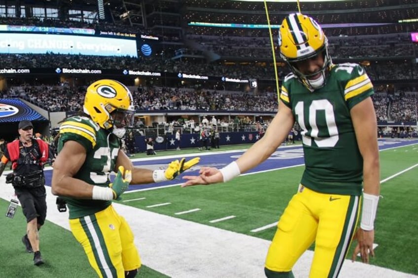 Aaron Jones (L) of the Green Bay Packers celebrates with quarterback Jordan Love following a second half touchdown in the win against the Dallas Cowboys in the NFC Wild Card Playoff game on Sunday.