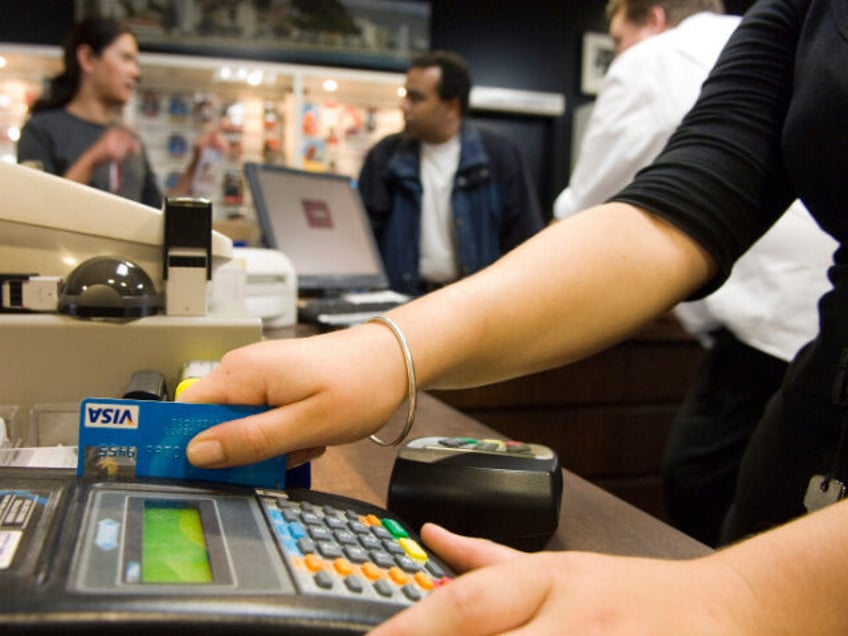 A sales clerk swipes a customer's Visa card at a shop in Wellington, New Zealand, on