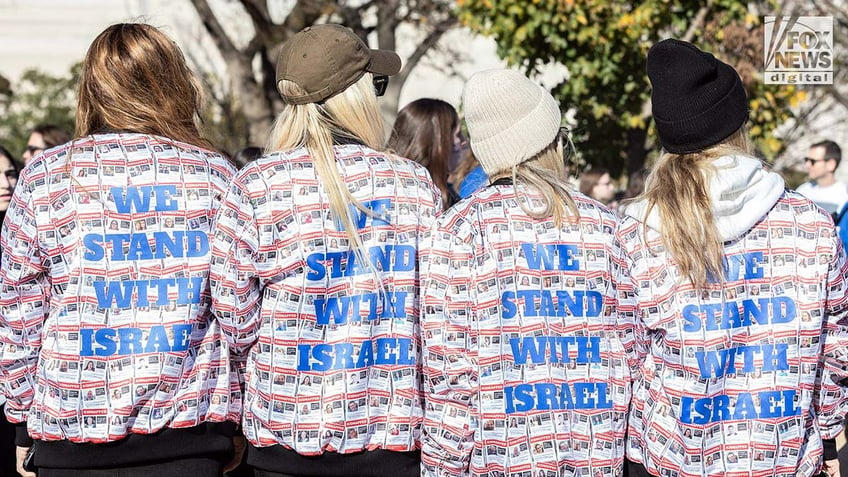 Demonstrators wear jackets showing Israeli hostages kidnapped by Hamas at the March for Israel