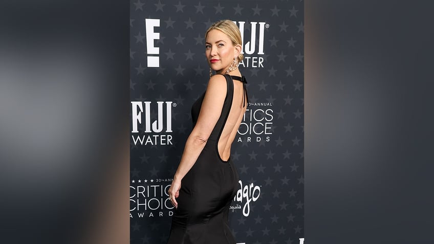 Kate Hudson walked the red carpet in a backless figure-hugging black gown.