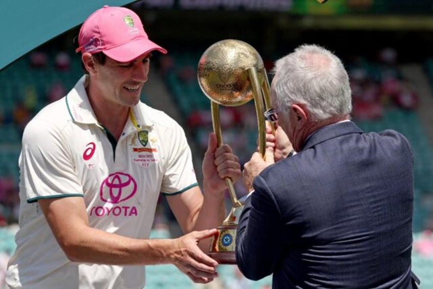 Australia captain Pat Cummins receives the Border-Gavaskar Trophy after winning the fifth