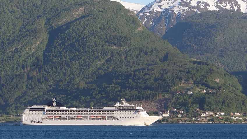An MSC Cruise ship sailing through a Norwegian fjord