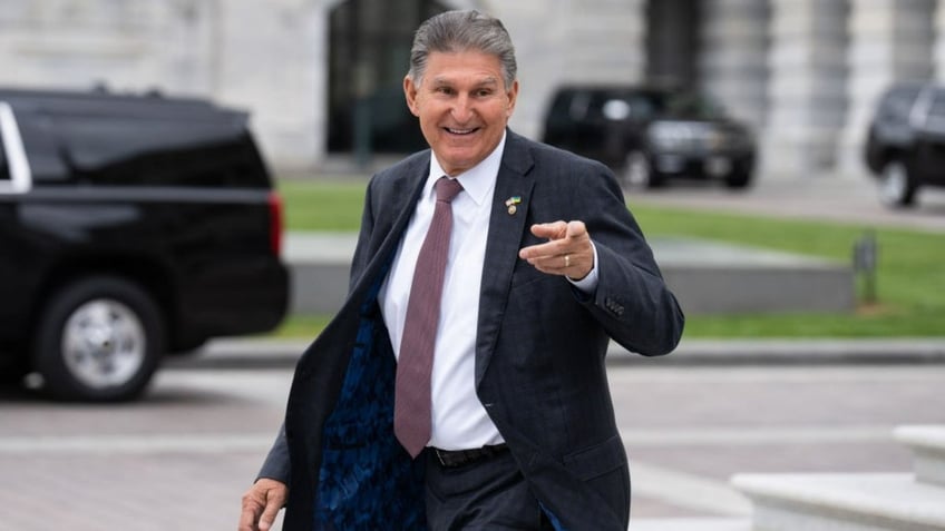 Sen. Joe Manchin pointing outside Capitol