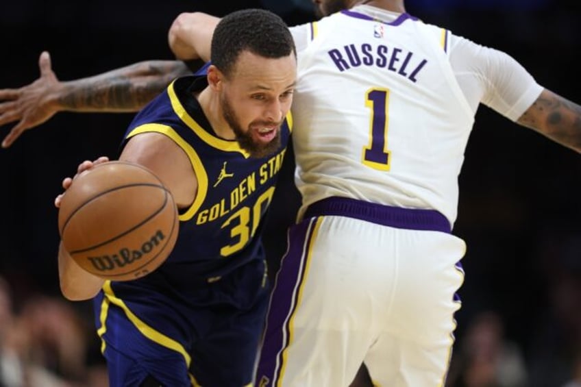 Stephen Curry of the Golden State Warriors, left, dribbles around D'Angelo Russell of the