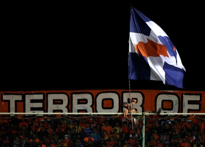 An APOEL fan in Nicosia waves a Cypriot flag during a UEFA Europa League match in 2012 -- Cyprus has for years struggled to control crowd violence