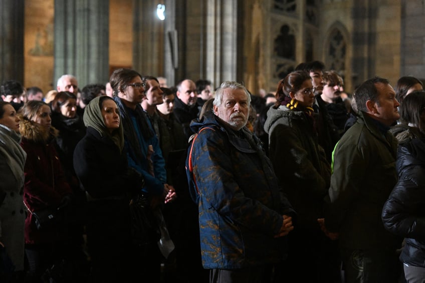 A man looks on as people stand at a mass commemorating the victims of the Charles University's shooting, at the St. Vitus Cathedral in Prague, on December 23, 2023, during a national mourning day. Flags on public buildings flew at half mast December 23, 2023 and masses were scheduled across the Czech Republic for a day of national mourning after a deadly shooting at Prague's Charles University -- the worst in the country in decades.