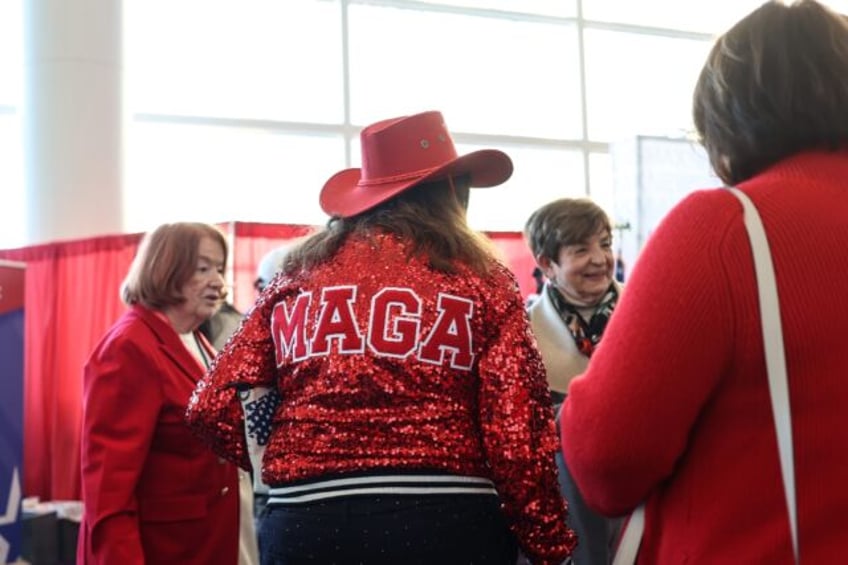 A woman wears a 'MAGA' jacket displaying her support for President Donald Trump at a major