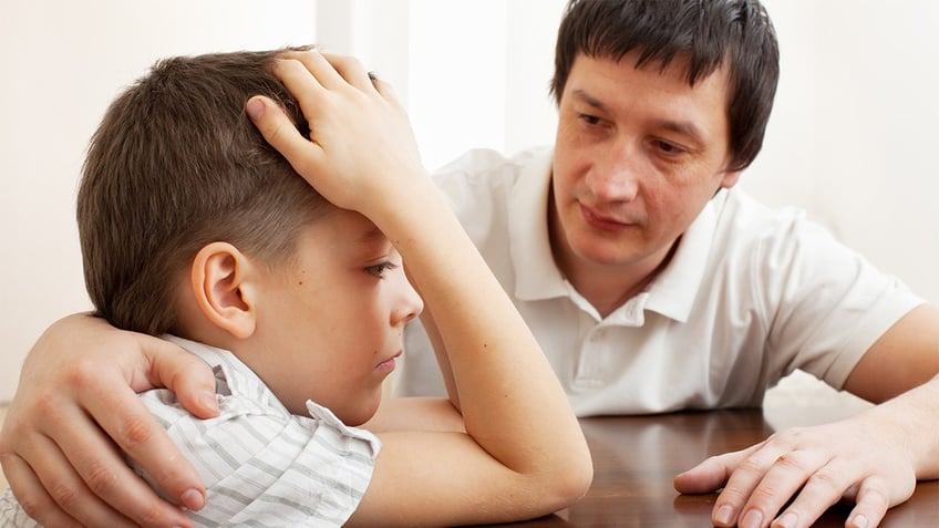 father comforts kid