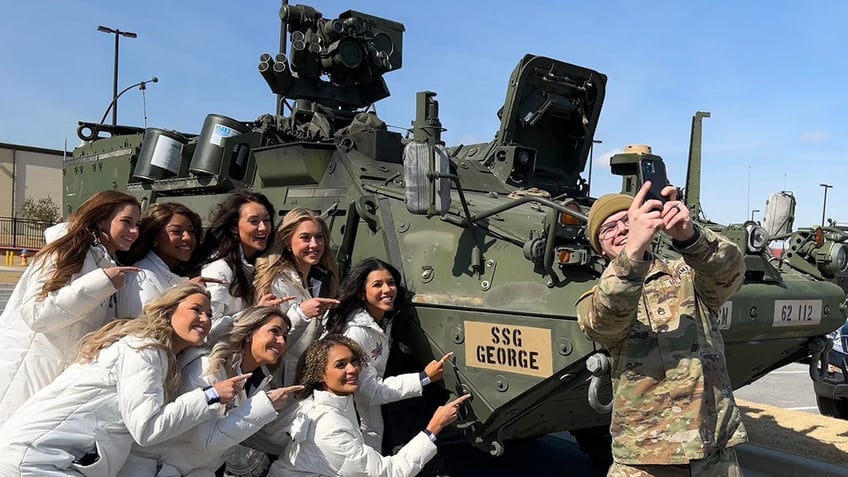 A serviceman taking a selfie with the Dallas Cowboys Cheerleaders