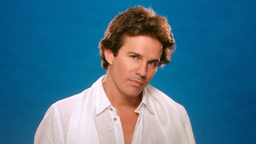 Dack Rambo wearing a white shirt.