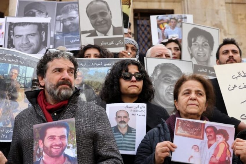 People hold portraits of missing relatives during the protest