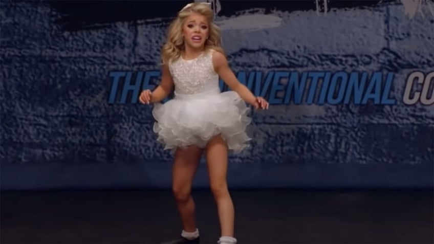 Ashlan dancing in a white tutu on stage,