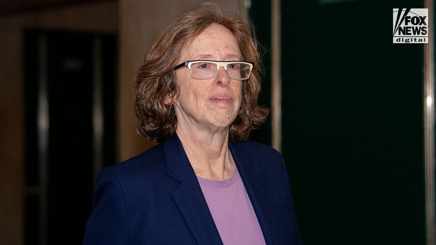 Prosecutor Dafna Yoran wears thick-brimmed white eyeglasses in the courthouse hallway