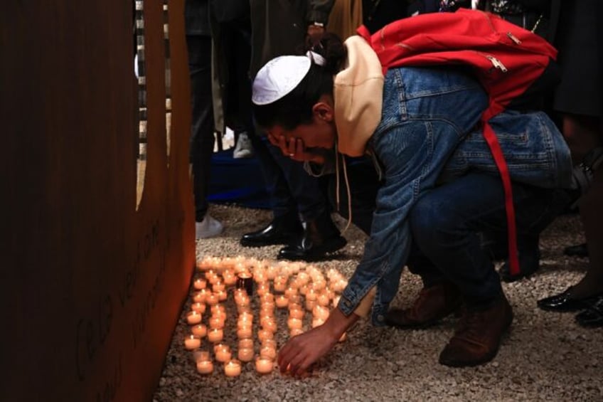 A mourner in Nice, France, lays down a candle at a ceremony in tribute of the victims of O