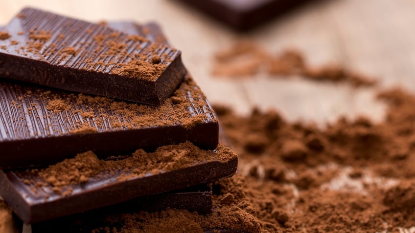 Dark Chocolate with Cocoa on Wooden Table