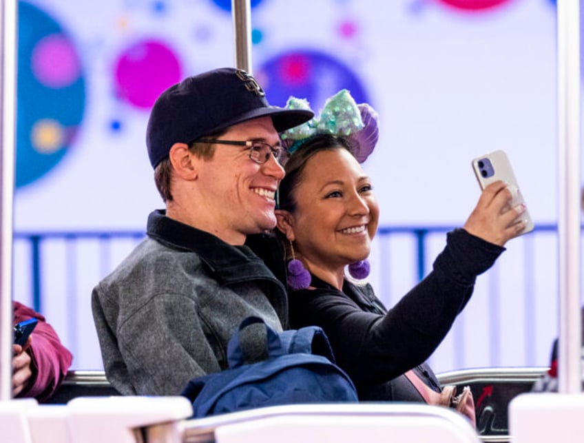 Anaheim, CA - February 23: A couple take a selfie on one of the parking lot trams at Disne