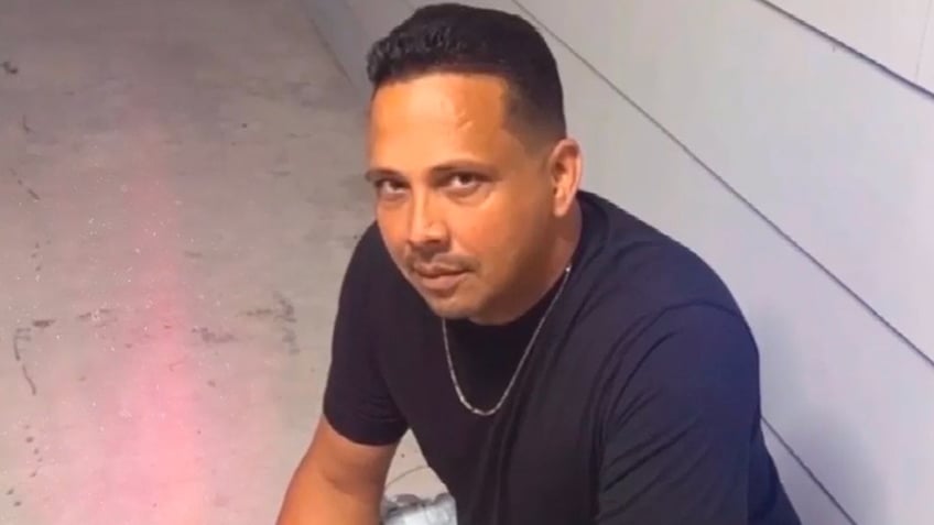 Davie Albarran wearing a black T-shirt and gold chain