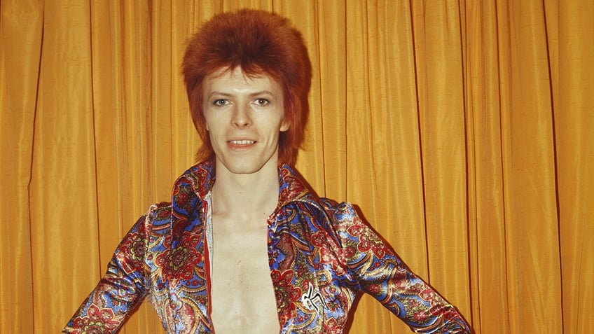 A close-up od David Bowie wearing a colorful blouse