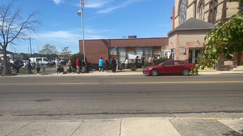 People are seen standing in line outside of the Saint Johns Lutheran Church Food Pantry in Springfield, Ohio.