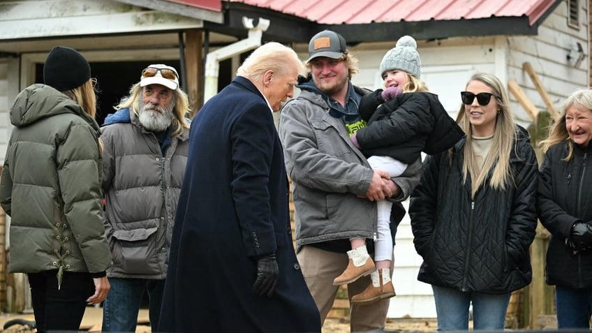 US President Donald Trump, with First Lady Melania Trump (L), visits a neighborhood affected by Hurricane Helene in Swannanoa, North Carolina, on January 24, 2025.