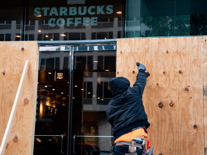 Wooden boards protect a Starbucks location near the White House on October 31, 2020 in Was