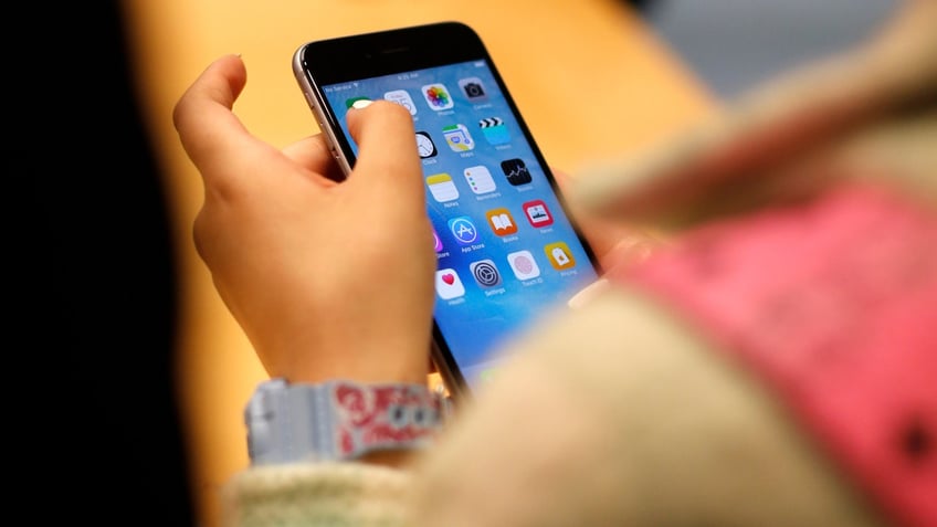 A child holds an iPhone at an Apple store on Sept. 25, 2015 in Chicago.