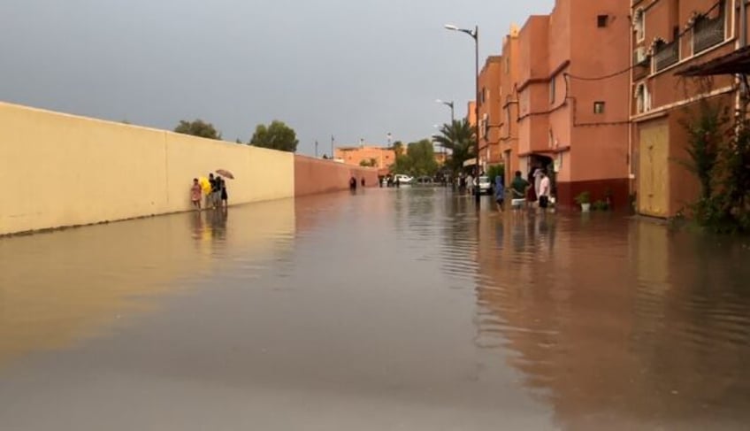 Residents walk on a flooded street in Morocco's Ouarzazate city on September 7, 2024