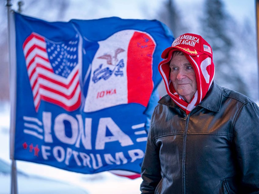 A man stands next to a flag that reads "Iowa for Trump" outside the the Machine Shed in Urbandale, Iowa, Jan. 11, 2024. Voters in Iowa will participate in caucuses Monday, Jan. 15, that will launch the GOP presidential nomination process. (AP Photo/Andrew Harnik, File)