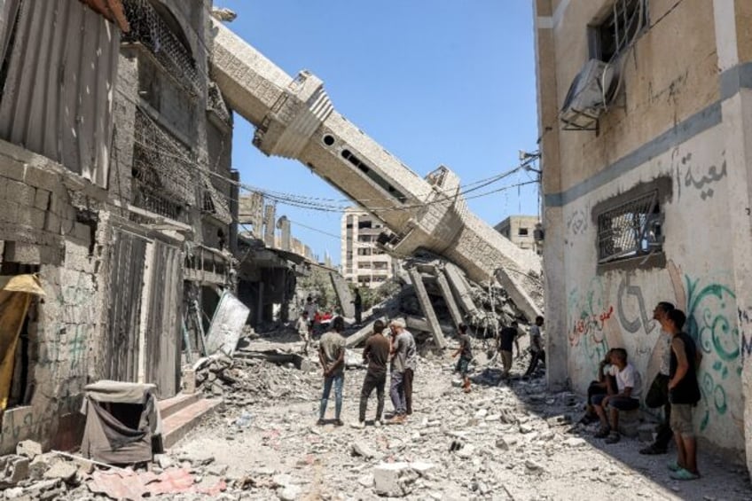 Palestinians inspect a minaret toppled by Israeli bombardment of Nuseirat refugee camp in