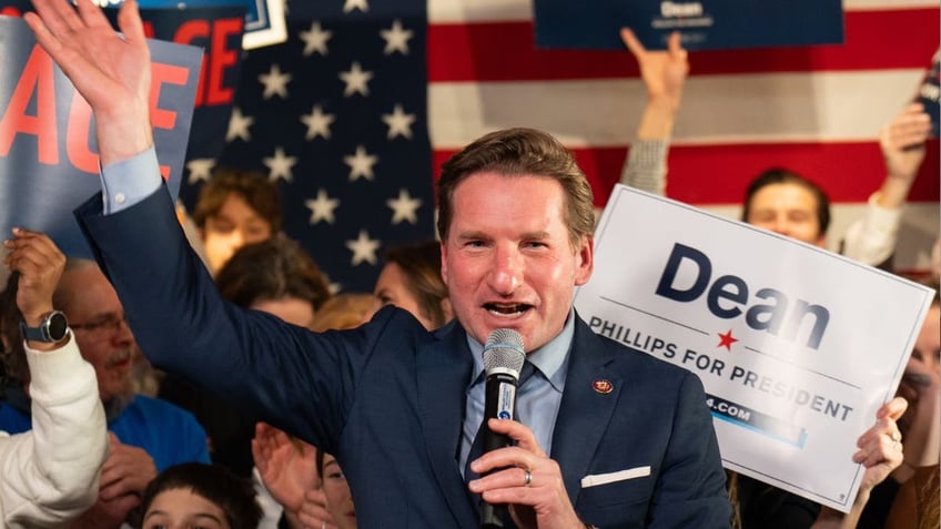 U.S. presidential election candidate Dean Philips speaks at an even flanked by supporters