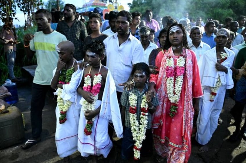 Children of victims who died after consuming toxic alcohol, arrive for a mass cremation in