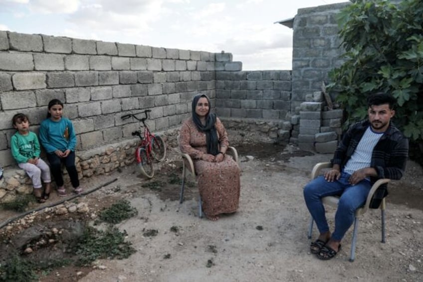 Bassem Eido, a 20-year-old Iraqi man from the Yazidi community, sits with his mother and s