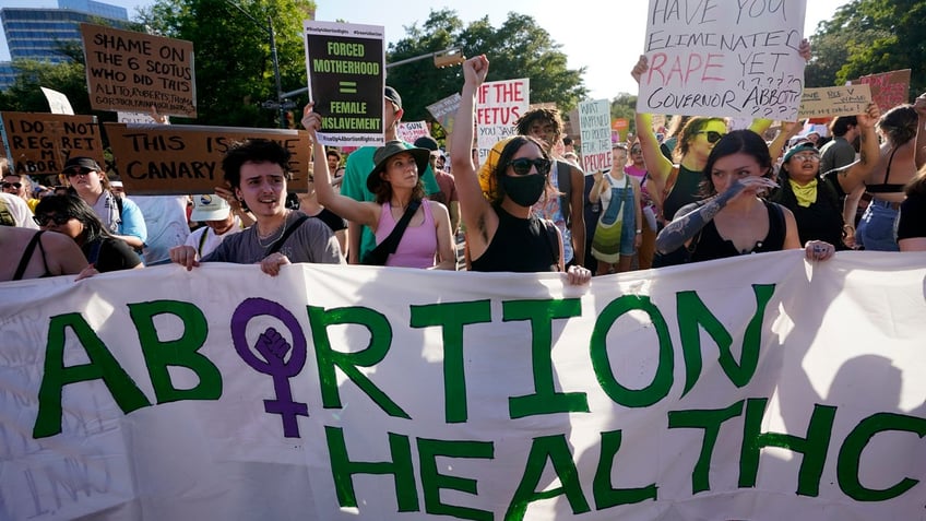 Demonstrators march and gather near the Texas state Capitol