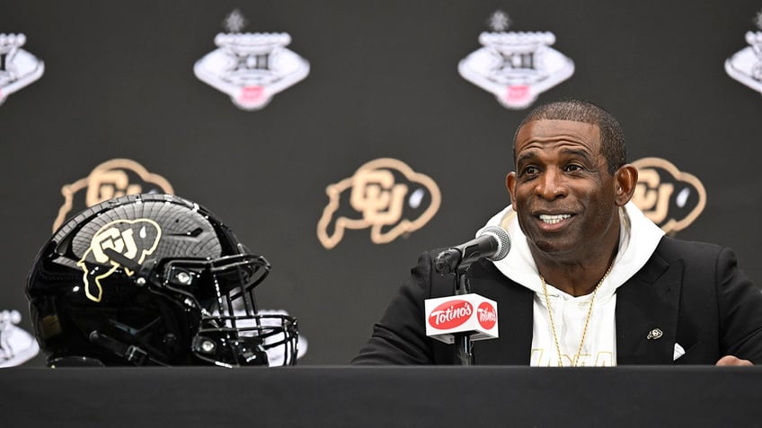 Deion Sanders talks to reporters