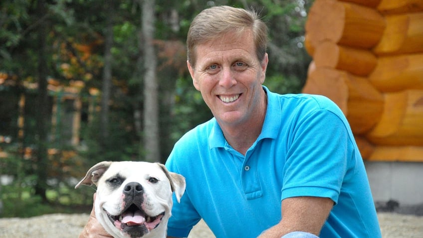 Mike Ramone smiles with a dog