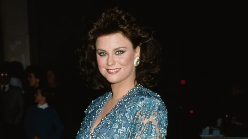 Delta Burke wears sparkling blue dress on the red carpet.