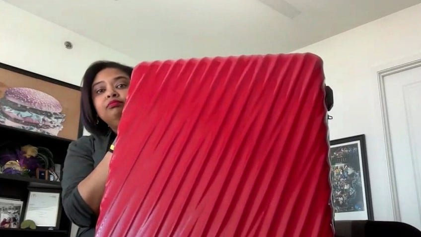 woman holding red suitcase