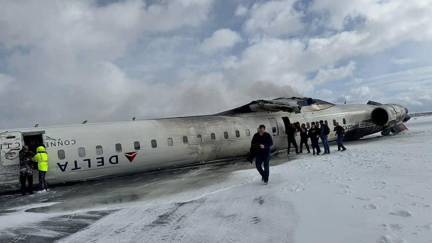 Passengers evacuate a Delta Air Lines plane