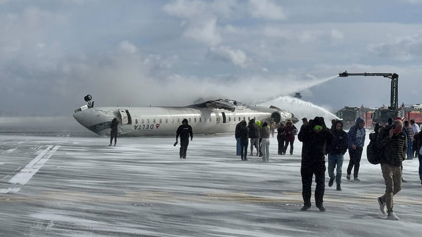 Passengers evacuate a Delta Air Lines plane