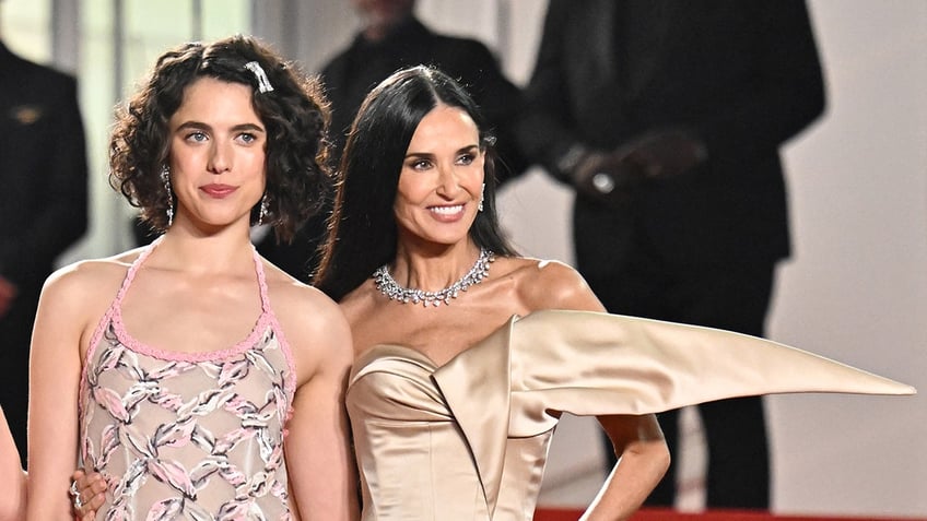 Margaret Qualley and Demi Moore posing together on the Cannes red carpet