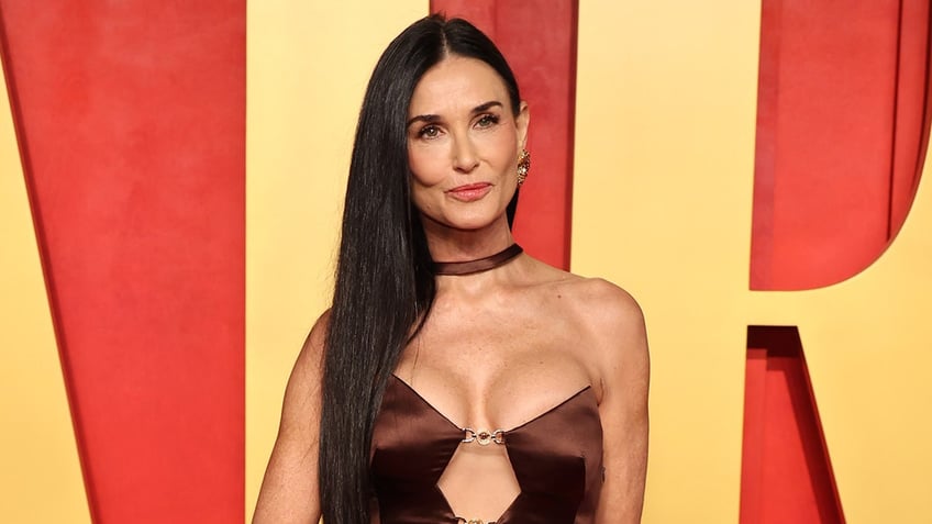 Demi Moore smiles on red carpet.