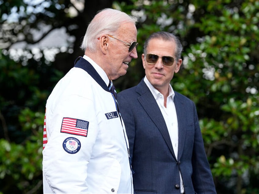 FILE - President Joe Biden, wearing a Team USA jacket and walking with his son Hunter Bide