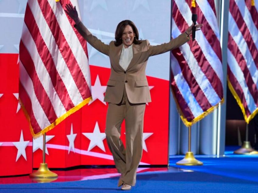 Democratic presidential nominee Vice President Kamala Harris raises her arms as she walks