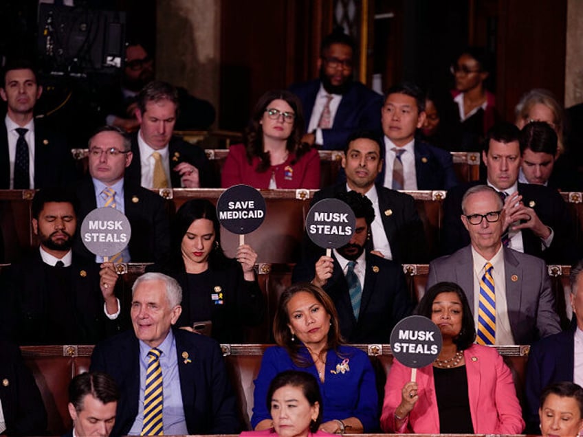 House Democrats hold signs in protest during a joint session of Congress in the House Cham