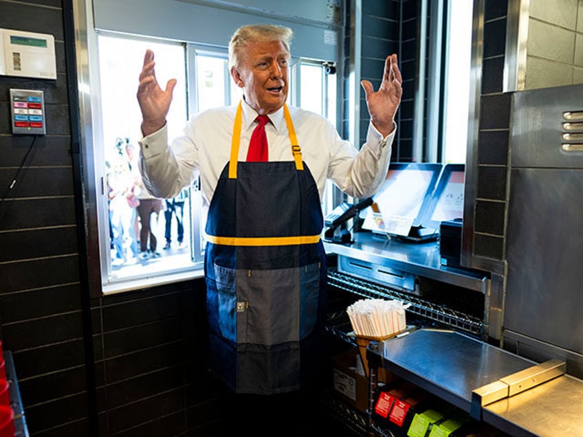 Republican presidential nominee former President Donald Trump stands at a drive-thru windo