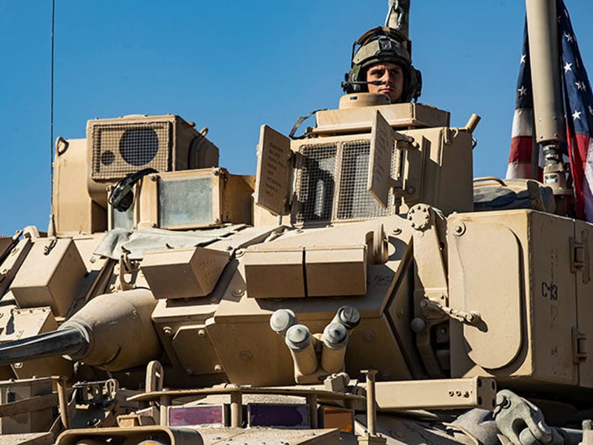 A US soldier monitors the area as troops patrol oil fields near Syria's northeastern borde