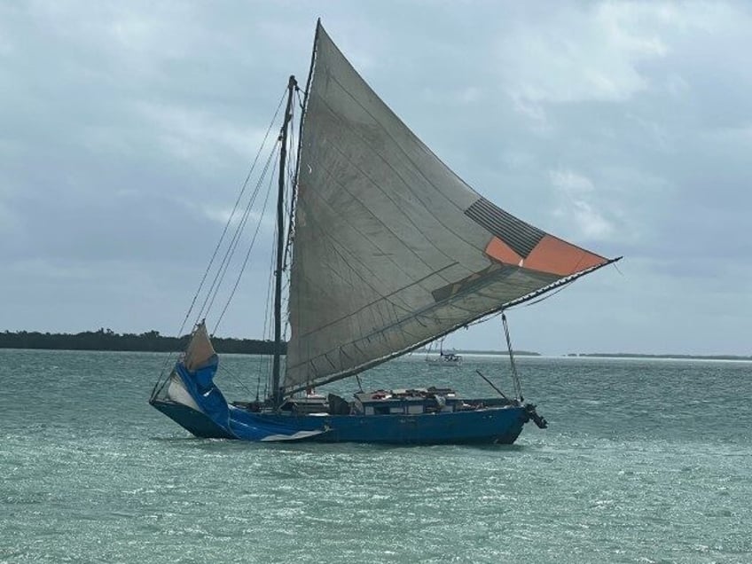 This photo provided by Monroe County Sheriff’s Office, a large wooden boat is grounded n