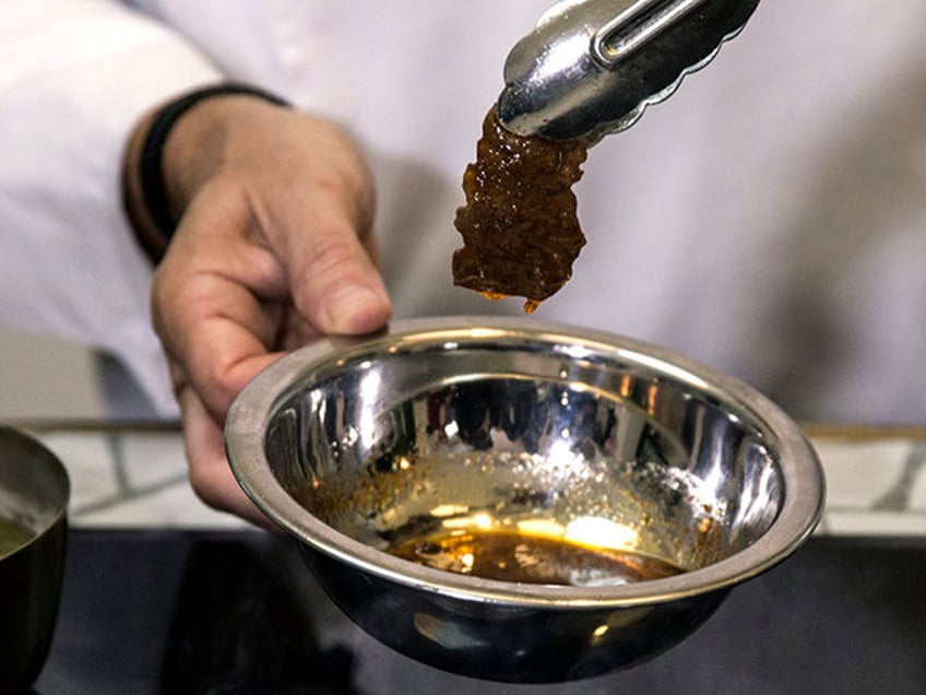 In this Wednesday, Jan. 16, 2019 photo, chef Amir Ilan prepares a lab-grown steak during a