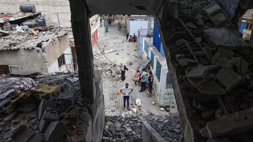 Palestinians asses the damage following an Israeli strike